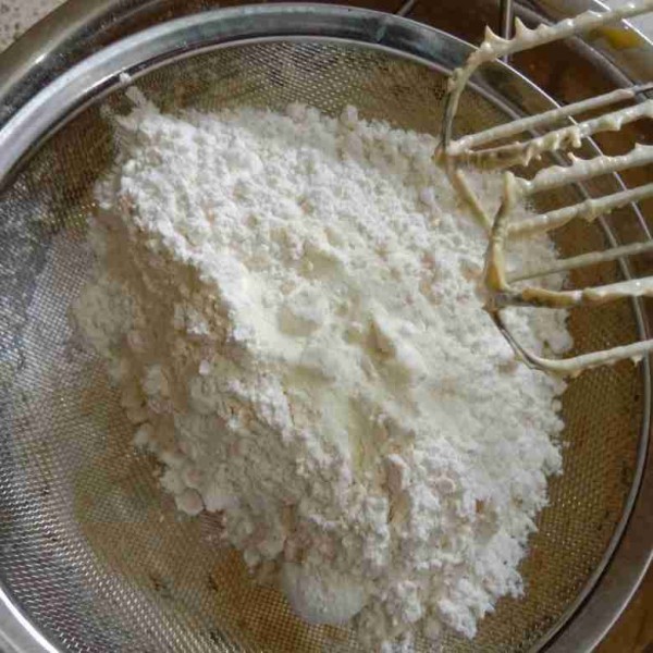 Masukkan campuran terigu, maizena, susu dan garam sambil diayak. Bertahap, mix kecepatan sedang.