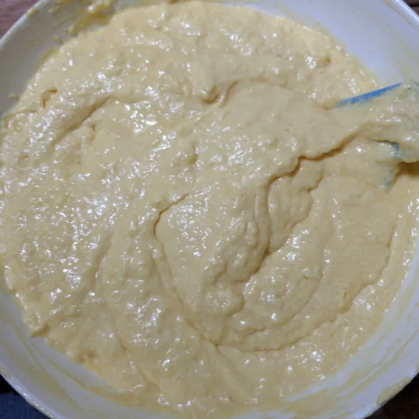 Tambahkan tepung terigu dan susu bubuk yang sudah disaring, aduk rata perlahan hingga adonan tercampur rata.