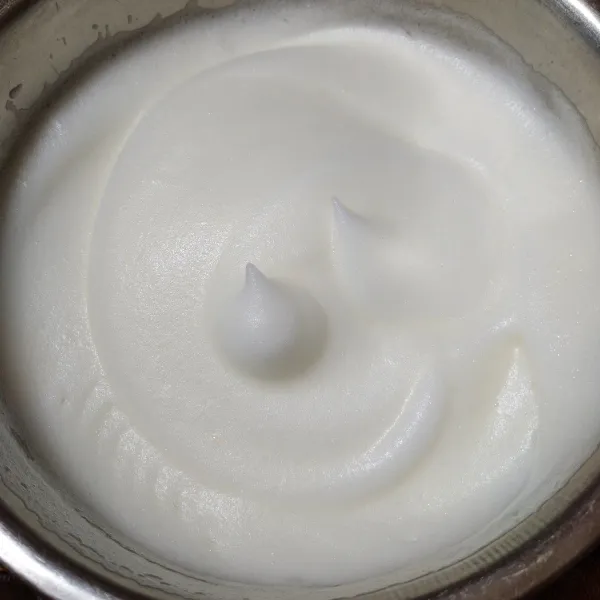 Mixer putih telur dengan kecepatan rendah, lalu pindah ke kecepatan tinggi setelah mulai berbusa hingga kaku. Sisihkan.