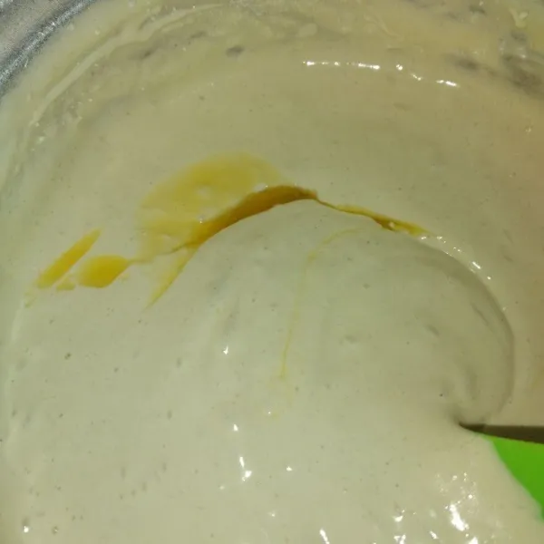Lalu masukkan butter cair , aduk dengan spatula hingga tercampur rata dan tidak ada endapan di bawah adonan .