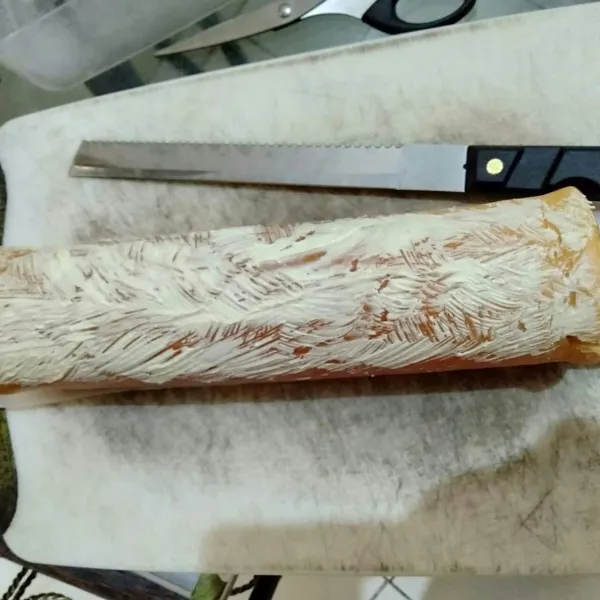 Gulung lagi, padatkan. beri topping buttercream lalu taburi dengan keju parut.