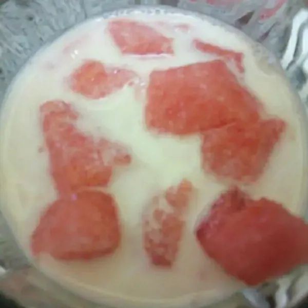 Dalam gelas saji, tuang susu tambahkan semangka.