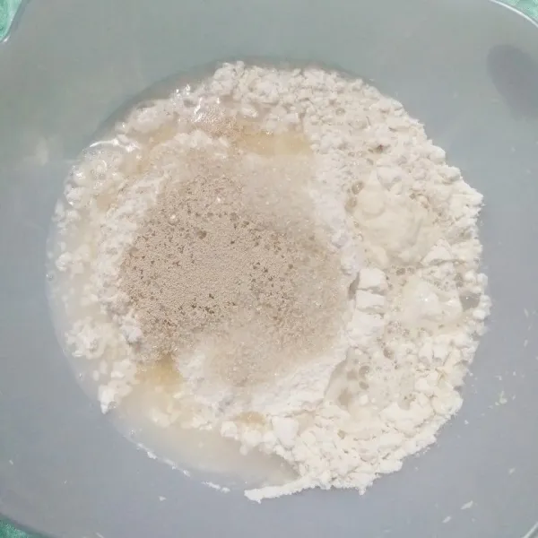 Masukkan tepung terigu, gula pasir, ragi instan dan air kedalam wadah. Mixer hingga kalis.