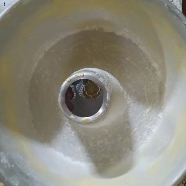 Oles loyang dengan margarine dan taburi terigu. Panaskan oven.