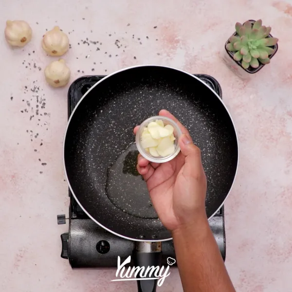 Tumis bawang putih dengan minyak panas dalam teflon hingga layu dan harum.