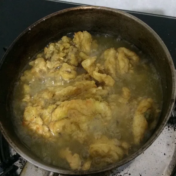 Siapkan minyak dalam panci agar ayam terendam saat menggoreng, masak hingga keemasan.
