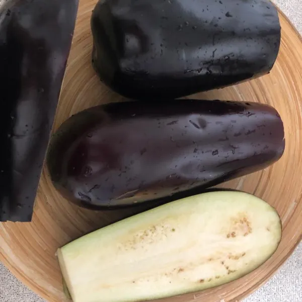 Potong aubergine menjadi 2 bagian memanjang.