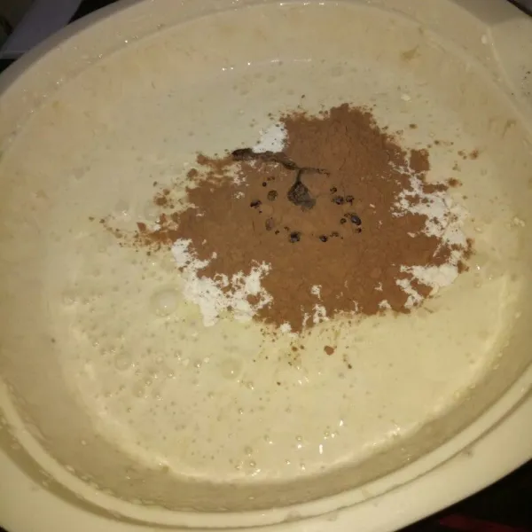 Ayak tepung terigu dan coklat bubuk. Masukkan ke dalam wadah adonan dan tambahkan essen coklat. Mixer dengan sped rendah asal rata.