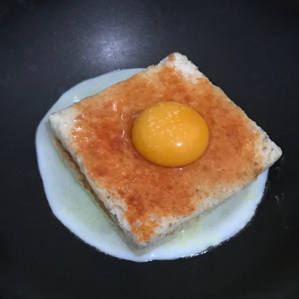 Letakkan telur secara perlahan diatas roti yang telah disiapkan.