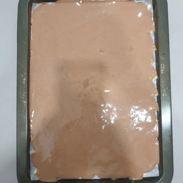 Masukkan pasta coklat, dan coklat. Chips yang dicincang halus, aduk rata, kemudian tuangkan ke atas loyang, tatakan dan hentakan beberapa kali. Panggang cake selama 10 menit dengan suhu 170 derajat celcius, angkat dan terbalikkan cake.