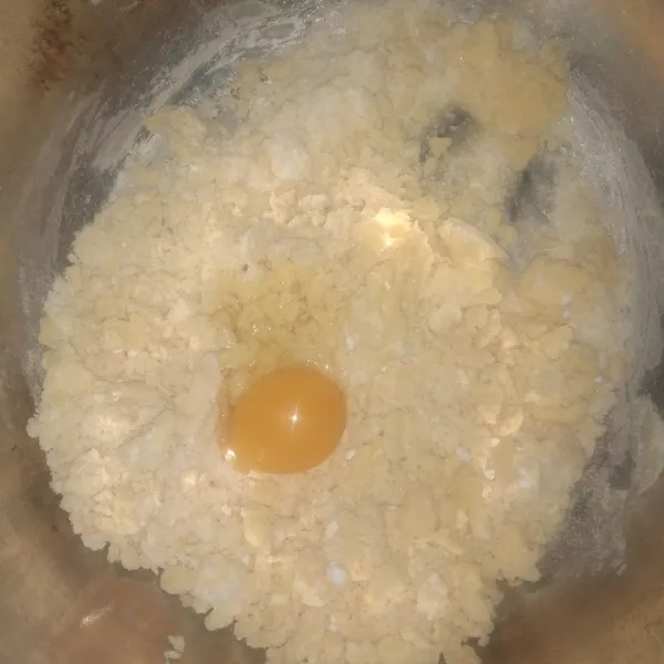 Kemudian masukkan kuning telur. Aduk hingga adonan merata.