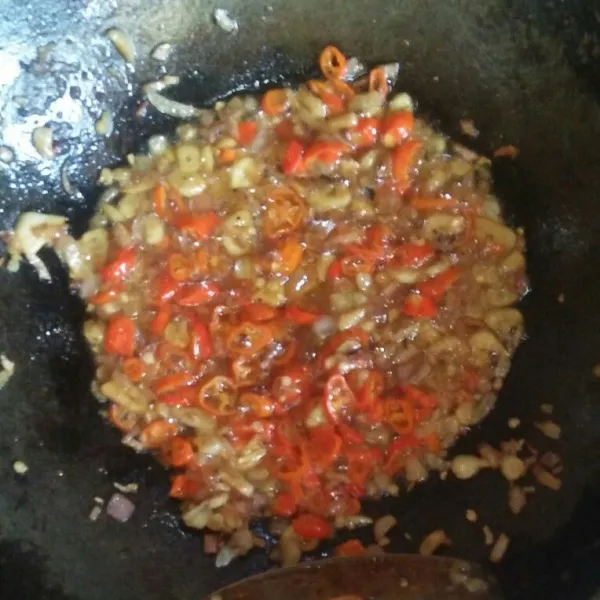 Panaskan minyak goreng. Tumis bawang merah dan bawang putih sampai layu. Lalu masukkan cabai rawit. Angkat dan sisihkan.