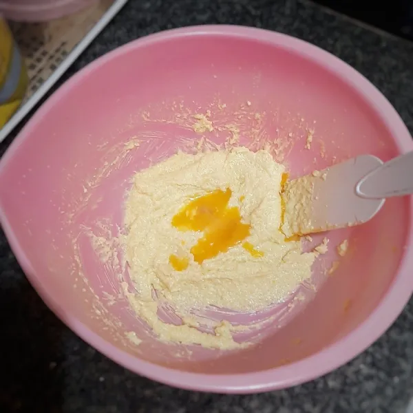 Di wadah lain, kocok margarin bersama gula halus hingga mengembang dan halus. Masukkan kuning telur, lalu kocok rata. Matikan mixer.