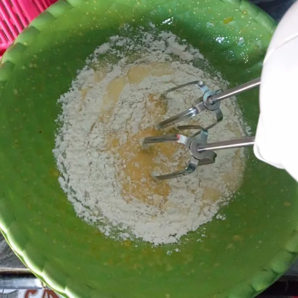 Kemudian tambahkan minyak, sambil di mixer dengan kecepatan rendah, tambahkan soya milk, kemudian tepung terigu, baking powder, garam, dan vanili, aduk hingga rata. Sisihkan.