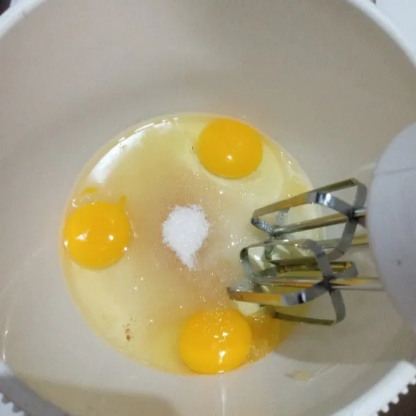 camput telur, gula pasir dan SP dalam bowl bersih