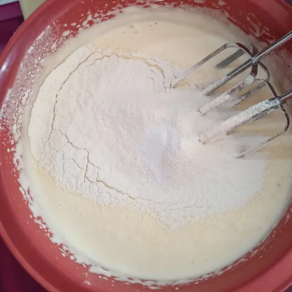 Tambahkan tepung terigu dan baking powder sambil di ayak, aduk balik.