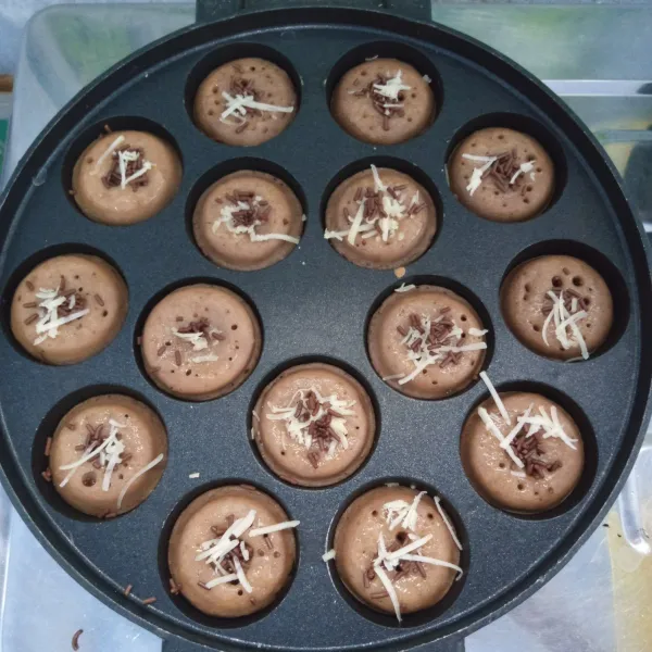 Setelah hampir matang. Olesi dengan margarin. Beri taburan mesis dan keju parut. Panggang sebentar. Angkat dan sajikan.