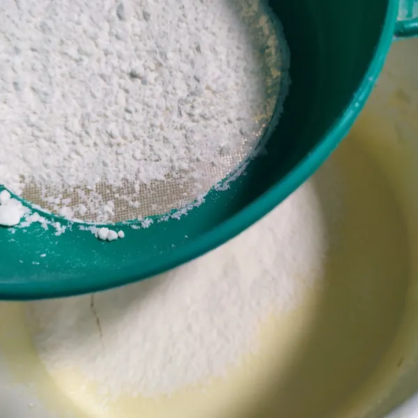 Kemudian masukan campuran tepung terigu, maizena dan susu bubuk sambil diayak, aduk hingga rata.