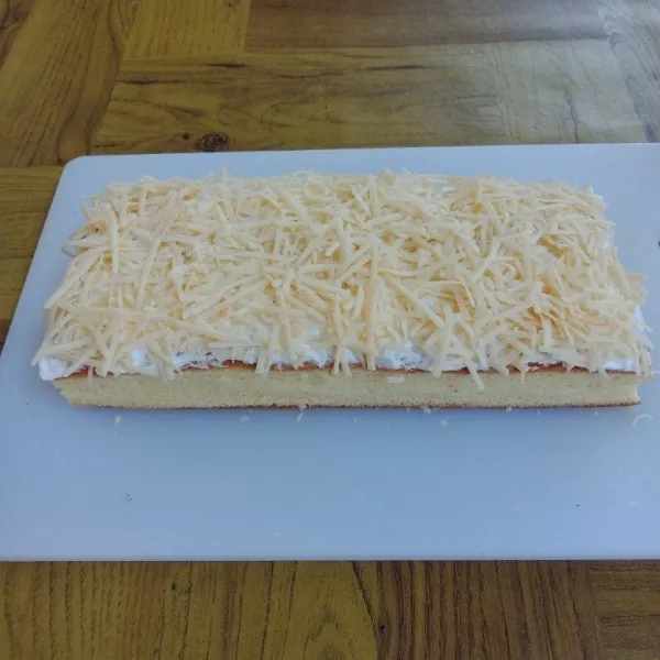 Setelah matang, biarkan sampai dingin, olesi dengan butter cream dan beri keju parut di atasnya.