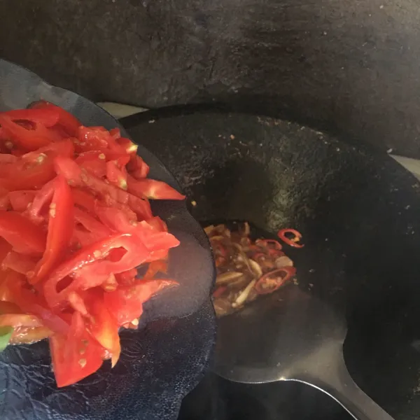 Setelah tumisan harum masukan tomat. Tumis hingga tomat layu lalu masukan gula pasir dan garam.