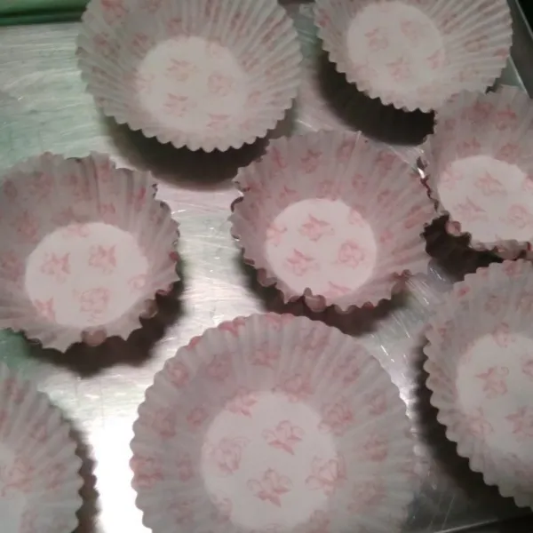 Siapkan kertas cupcake di alas cetakan pie atau bisa menggunakan loyang khusus cupcake. Tuang adonan dengan sendok.