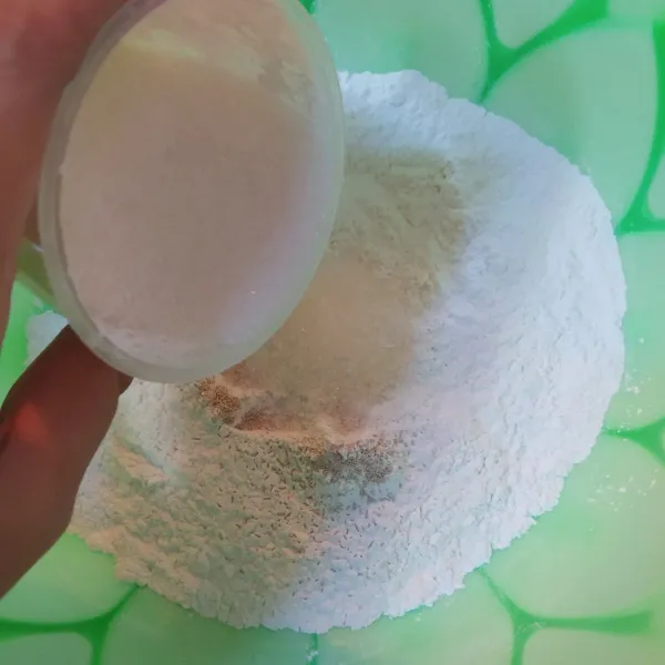 Tuangkan semua bahan kering (sisakan sedikit gula untuk taburan) lalu aduk rata.