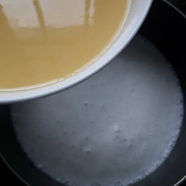 Masukkan adonan tepung ke dalam panci berisi air kelapa dan uht. Aduk rata.