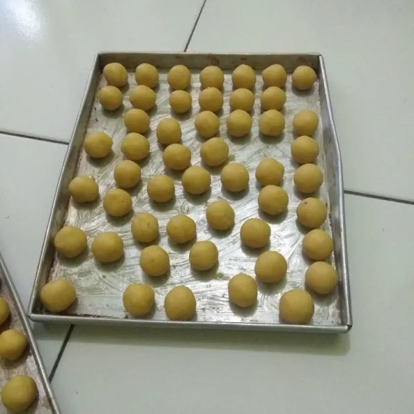 Kemudian bentuk adonan menjadi bulatan-bulatan kecil. Tata di dalam loyang yang sudah diolesi margarin tipis sebelumnya. Panaskan oven dan panggang kue sampai matang sesuai dengan oven masing masing.