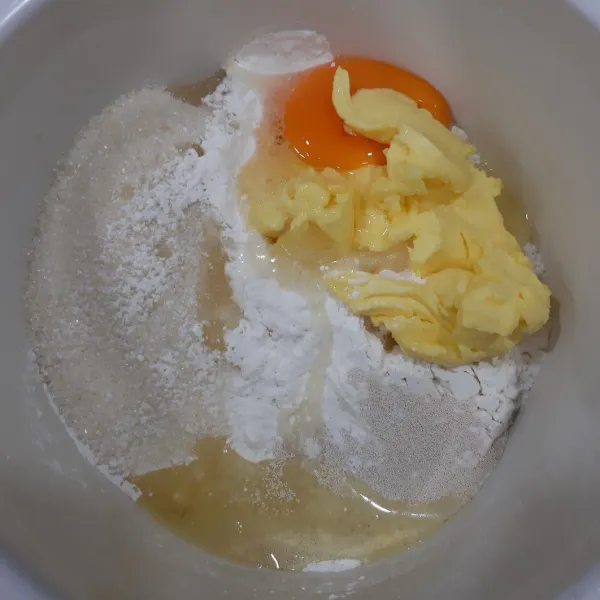Masukkan terigu, ragi, gula, mentega dan telur ke dalam mix bowl.