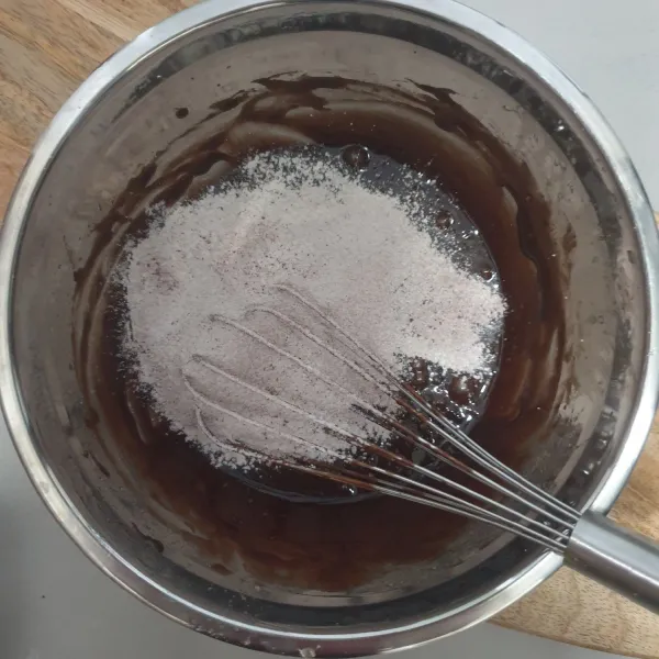 Masukkan campuran tepung terigu dan coklat bubuk yang telah diayak, aduk sampai tercampur rata.