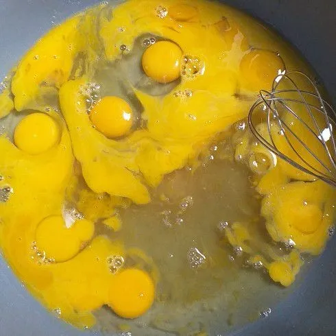 Masukkan ke dalam wadah baskom telur dan sisa gula. Aduk hingga tercampur rata.