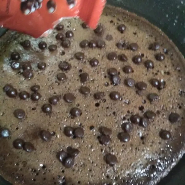 Sesaat sebelum brownies selesai dipanggang, taburi atasnya dengan topping chocochips.