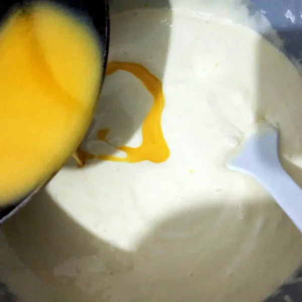 Tambahkan butter cair bertahap, aduk balik dengan spatula hingga homogen.