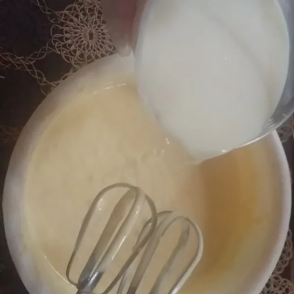 Tuang SKM dan air ke dalam adonan kocok sebentar dengan kecepatan mixer rendah.