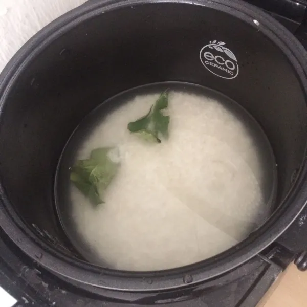 Tambahkan daun salam, garam, merica, dan kaldu ayam lalu aduk dan setting rice cooker pada pengaturan memasak bubur.