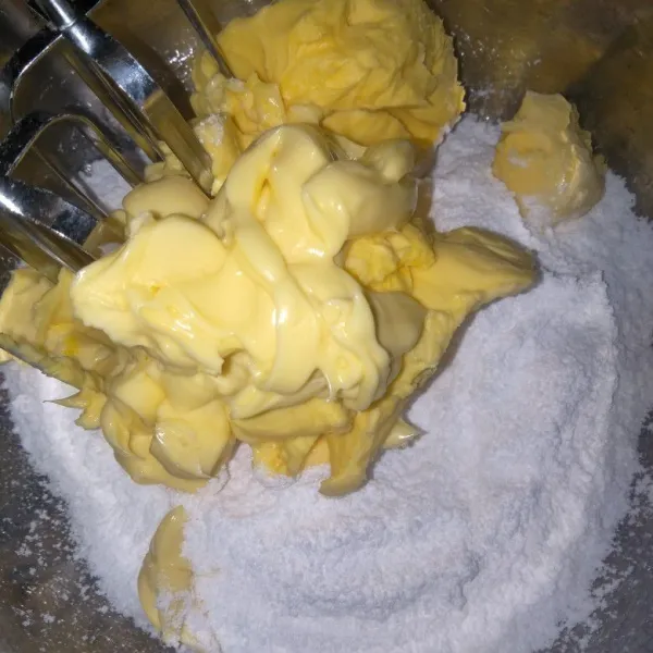 Mixer kecepatan tinggi butter dan gula halus, hingga putih.