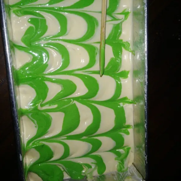 Tuang adonan pada loyang yang telah dialasi kertas.lalu beri motif adonan hijau, pakai bantuan tusuk sate dengan ditarik ke bawah. Oven selama kurleb 20menit,dibawah loyang beri baskom berisi air.
