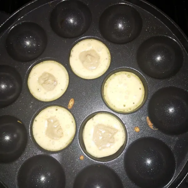 Panaskan cetakan, tuang adonan setinggi ½ cetakan. lalu isi ¼sdt selai, tutup atas selai dengan adonan. lalu balik. masak hingga semua bagian coklat merata. Sajikan dengan taburan gula halus