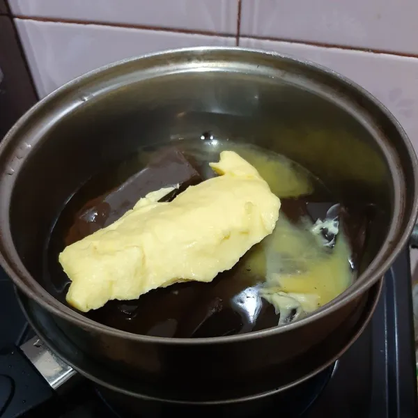 Lelehkan coklat blok, minyak goreng dan butter dengan cara ditim. Biarkan dingin, sisihkan.