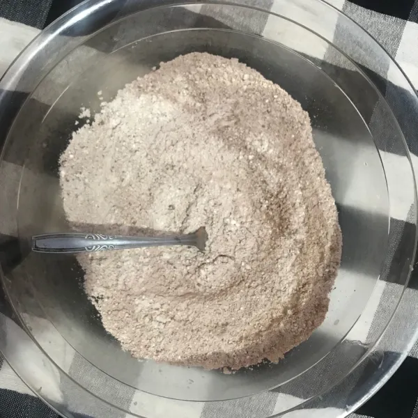 Siapkan wadah B. Masukkan tepung terigu, cokelat bubuk, baking powder, baking soda, vanila bubuk. Campur rata dan boleh diayak secara bersamaan.