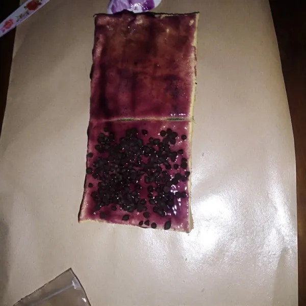 Angkat, keluarkan dari loyang. Lalu oles dengan selai. Taburi dengan chocochip. Lalu tumpuk.