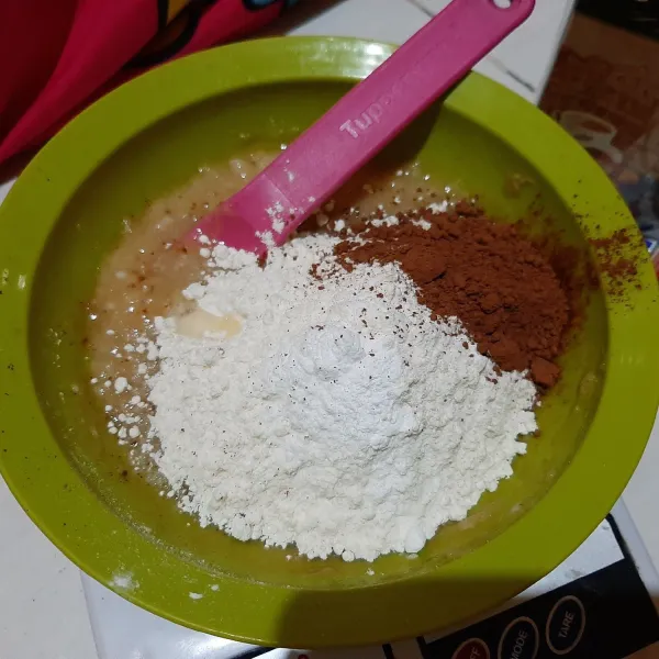 Tambahkan tepung terigu, coklat bubuk dan vanilla essens, aduk rata.