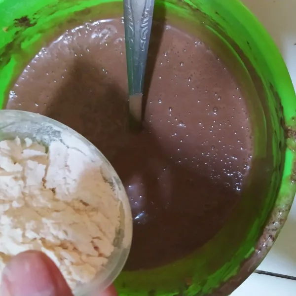 Tambahkan tepung terigu sedikit demi sedikit, serta tambahkan baking powder aduk sampai semua benar benar rata.