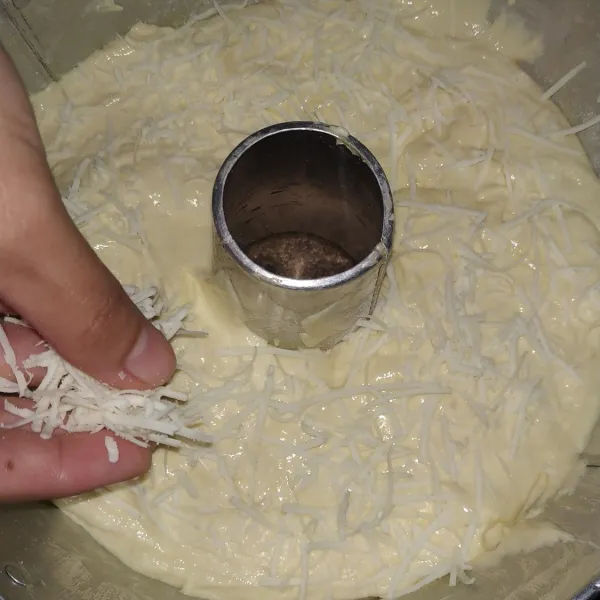 Siapkan loyang bulat tulban, olesi dengan margarin dan tepung. Masukkan adonan kedalam loyang dan taburi dengan keju parut.