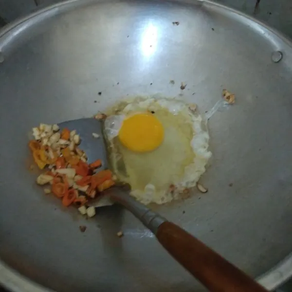 Masukkan telur dan buat orak-arik. Kemudian aduk rata telur, bawang putih dan cabai rawit.