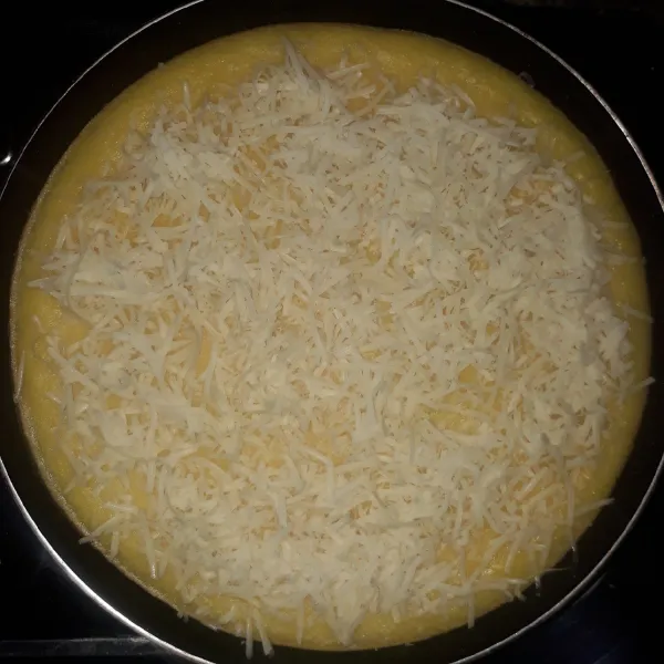 Tambahkan keju parut di atas permukaan roti. Panggang selama 15 menit sampai kue matang. Angkat.