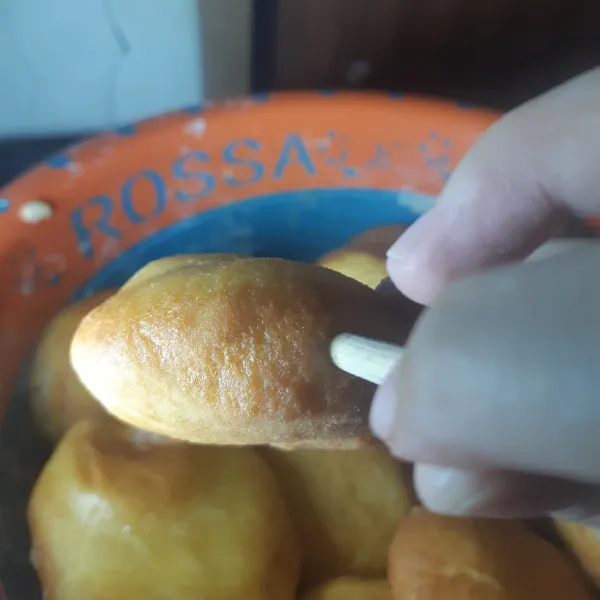 Lubangi pinggiran donat menggunakan sumpit untuk di isi dengan coklat.