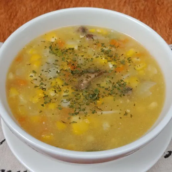 Sajikan sup krim jagung dengan taburan parsley.