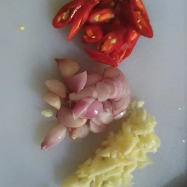 Iris tipis bawang merah dan bawang putih. Irisi menyerong cabe merah.