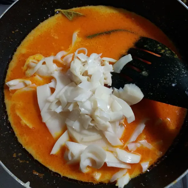 Lalu tambahkan air dan santan, kemudian masukkan rebung yang sudah direbus, aduk rata.